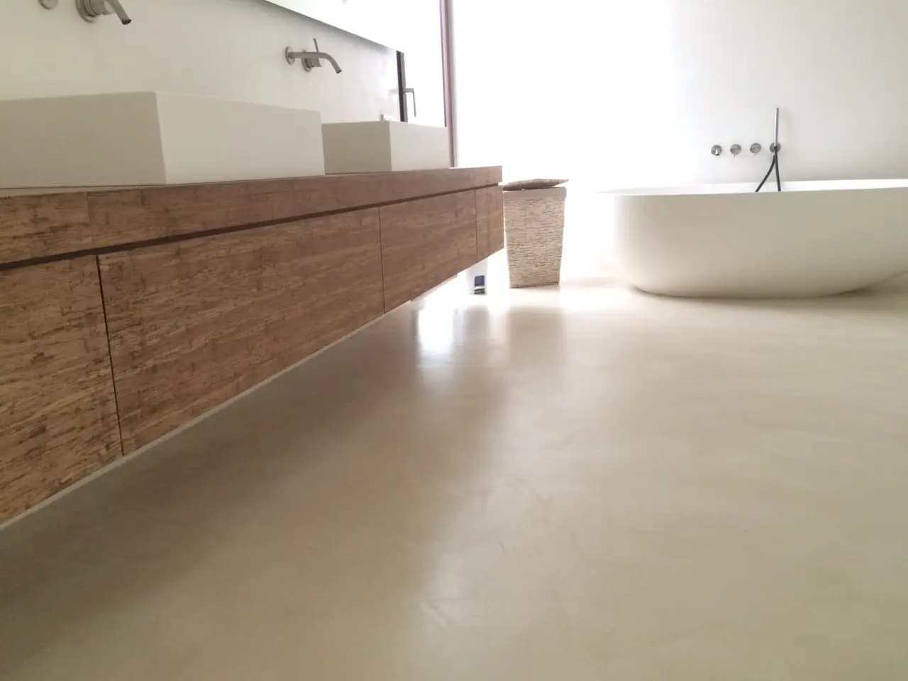 Baño reformado con microcemento gris claro continuo y sin juntas en Málaga